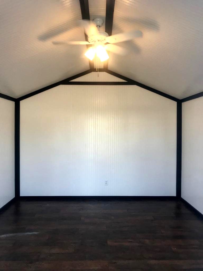 Vaulted beadboard ceiling with black trim and a ceiling fan