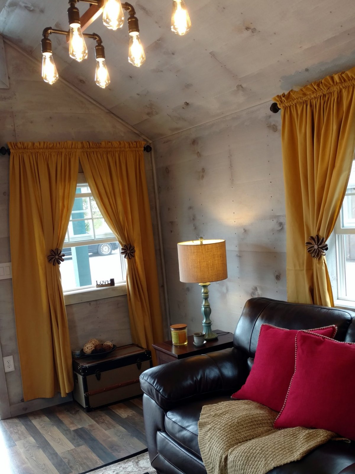 Rustic finished studio with pine plank walls, Edison light fixture and leather sofa